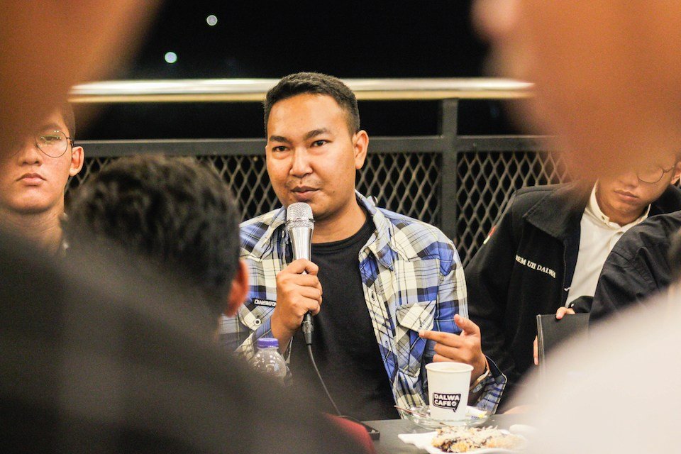 A speaker holding a microphone addressing the room