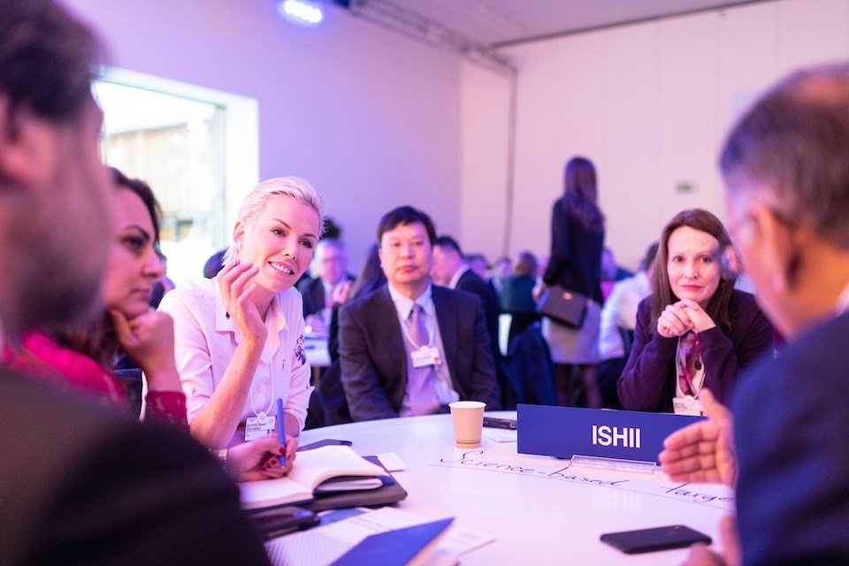 Professionals gathered around a table in conversation